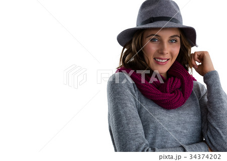 Portrait of smiling woman wearing hat and scarf Portrait of smiling woman wearing hat and scarf 34374202