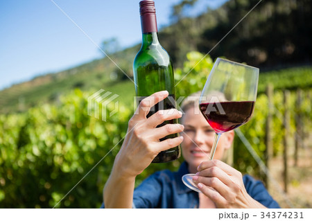 Female vintner examining wine 34374231