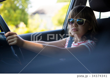 Teenage girl driving a car 34374341