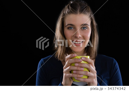 Portrait of woman holding coffee cup 34374342