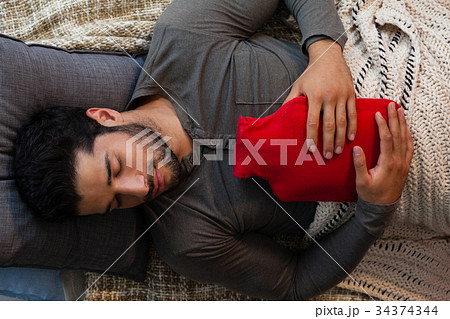 Man sleeping with hot water bag 34374344