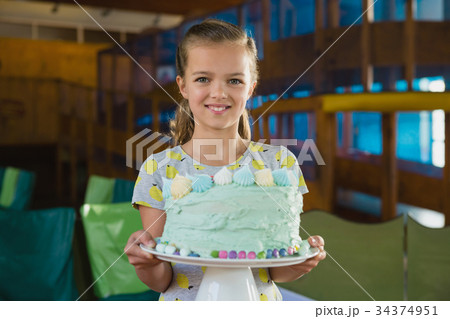 Portrait of smiling girl holding cake 34374951