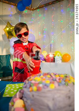 Cute boy pretending to be a fireman during birthday party 34374965