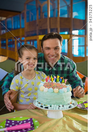Father and daughter with birthday cake at home Father and daughter with birthday cake at home 34375225