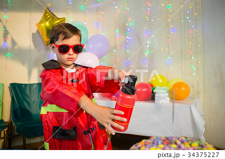 Cute boy pretending to be a fireman during birthday party Cute boy pretending to be a fireman during birthday party 34375227