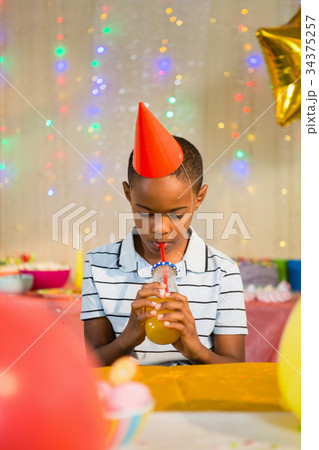 Boy drinking juice during birthday party 34375257