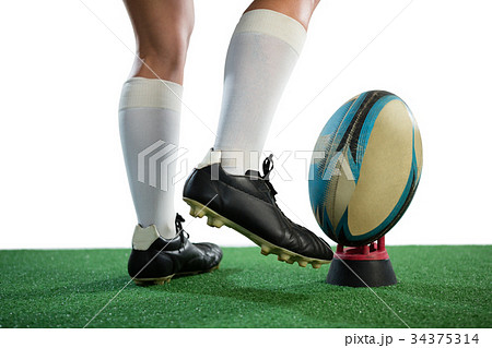 Low section of sportswoman kicking rugby ball 34375314