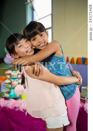 Kids embracing each other during birthday party at home 34375408