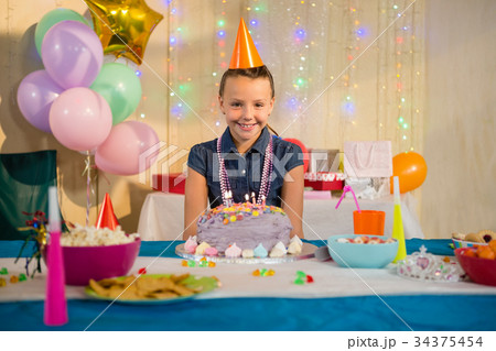 Girl standing with birthday cake at home 34375454