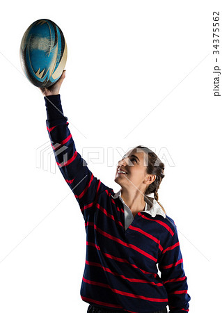 Happy female athlete with arms raised holding rugby ball 34375562