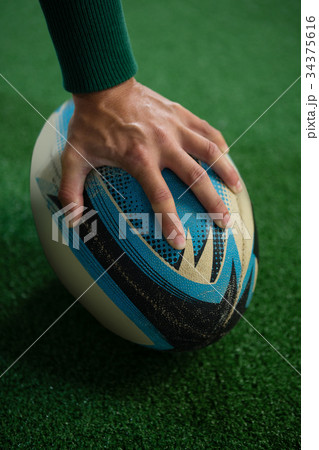 Cropped image of hand holding rugby ball 34375616