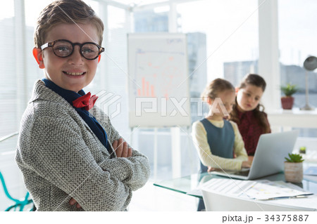 Portrait of confident businessman with female colleagues in background 34375887