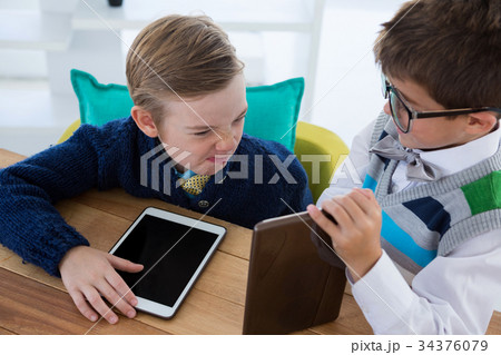 Kids as business executives interacting while using digital tablet 34376079