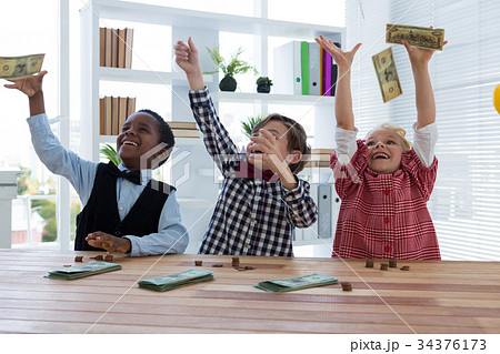 happy business people throwing money in air at office 34376173