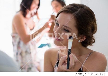 Bride applying her makeup doing her wedding preparation Bride applying her makeup doing her wedding preparation 34376177