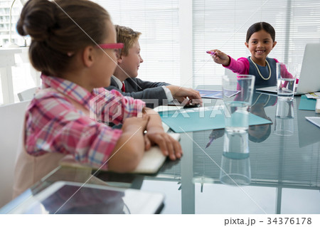 Kids as business executives interacting while meeting Kids as business executives interacting while meeting 34376178