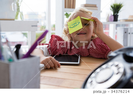 Port5rait of playful businesswoman with adhesive notes on eyes at office Port5rait of playful businesswoman with adhesive notes on eyes at office 34376214