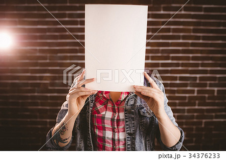 Woman hiding face from blank sheet 34376233