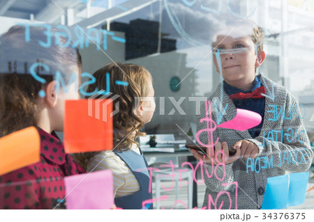Business people analyzing data at office seen through glass Business people analyzing data at office seen through glass 34376375