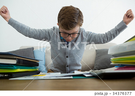 Frustrated businessman with arms outstretched sitting on sofa 34376377