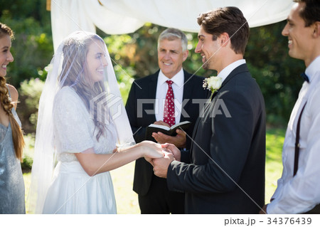 Minister giving speech to bride and groom 34376439