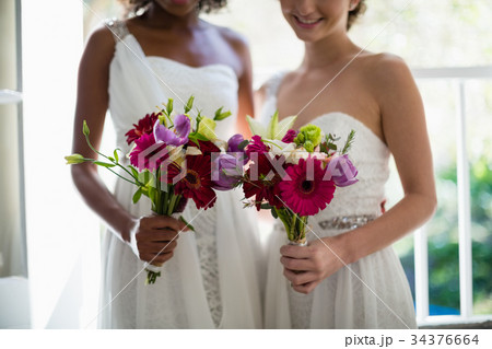 Bride and bridesmaids standing with bouquet Bride and bridesmaids standing with bouquet 34376664
