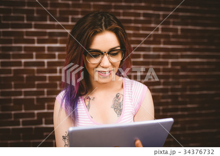 Smiling woman using digital tablet 34376732