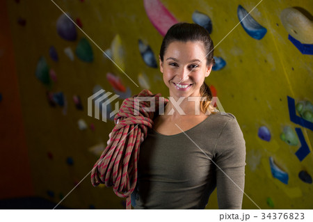 Happy woman with rope in fitness studio 34376823