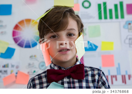 Close up portrait of businessman with sticky notes standing against whiteboard in office 34376868
