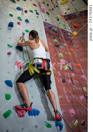Woman practicing rock climbing in fitness studio Woman practicing rock climbing in fitness studio 34376881