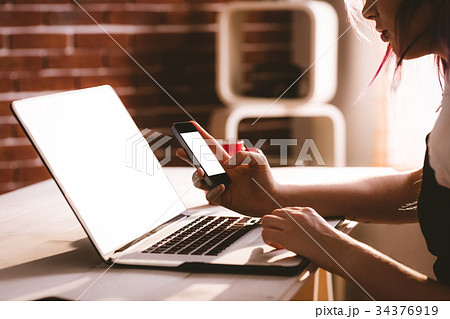 Attentive executive using laptop and mobile phone 34376919