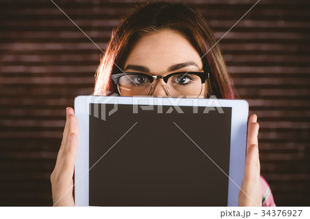 Portrait of woman hiding face from digital tablet 34376927