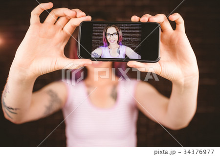 Smiling woman taking selfie from mobile phone Smiling woman taking selfie from mobile phone 34376977
