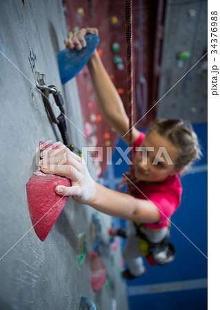 Determined teenage girl practicing rock climbing 34376988
