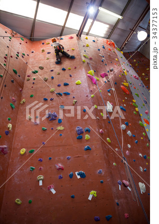 Determined boy practicing rock climbing 34377153