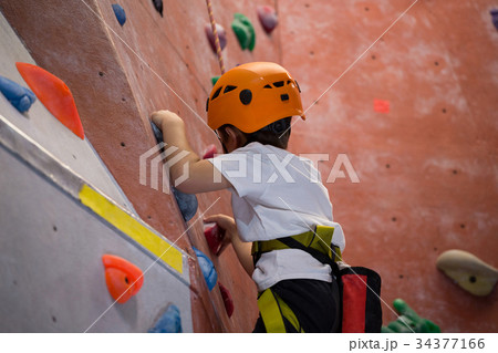 Determined boy practicing rock climbing Determined boy practicing rock climbing 34377166