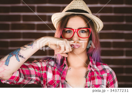 Beautiful woman pretending to have a fake moustache Beautiful woman pretending to have a fake moustache 34377231