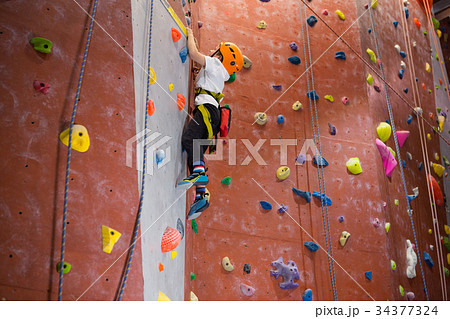 Determined boy practicing rock climbing 34377324