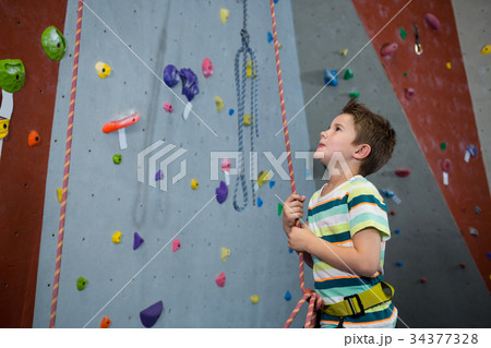 Boy preparing for rope climbing in fitness studio Boy preparing for rope climbing in fitness studio 34377328