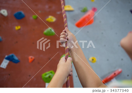 Boy practicing rope climbing in fitness studio 34377340