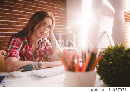 Tensed executive sitting with hand on forehead 34377371