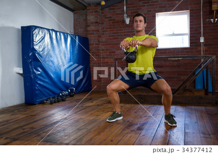 Determined man exercising with kettlebell 34377412