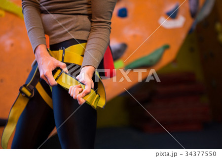 Mid section of woman wearing safety harness Mid section of woman wearing safety harness 34377550