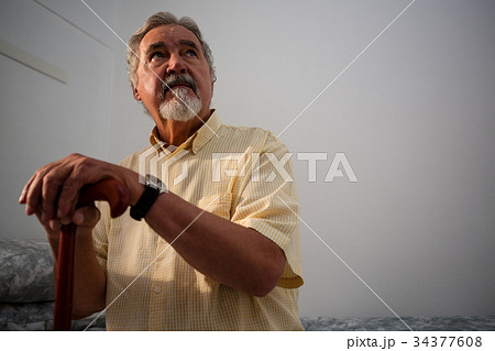 Thoughtful senior man standing outdoors during foggy weather 34377608