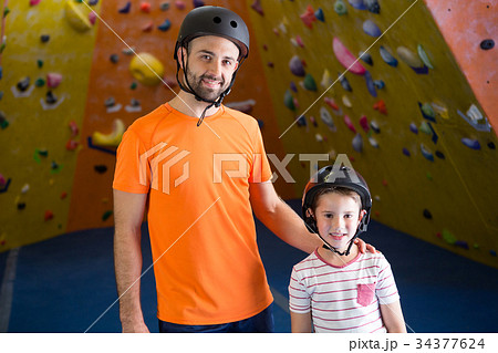 Portrait of trainer and kids standing in fitness studio 34377624