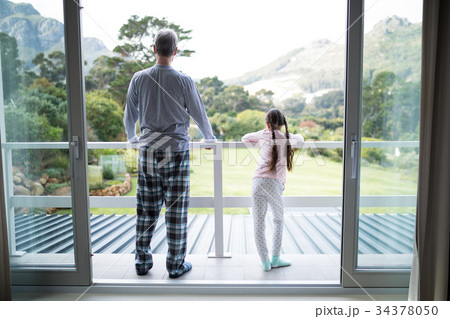 Father and daughter standing together in balcony 34378050