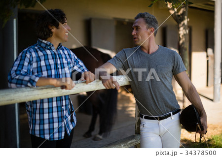 Two male friends interacting with each other in the ranch 34378500