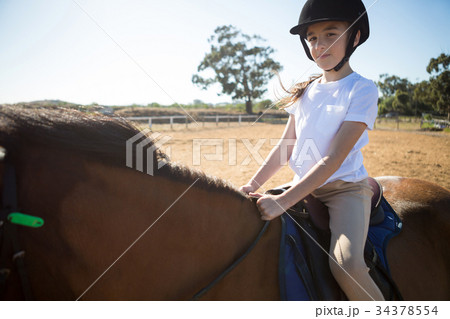 Girl riding a horse in the ranch Girl riding a horse in the ranch 34378554