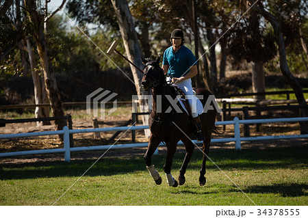 Male jockey riding horse in the ranch Male jockey riding horse in the ranch 34378555