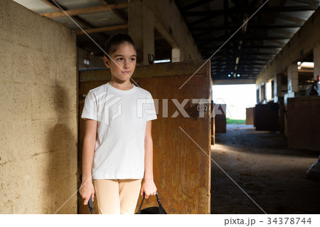 Girl standing in stable 34378744